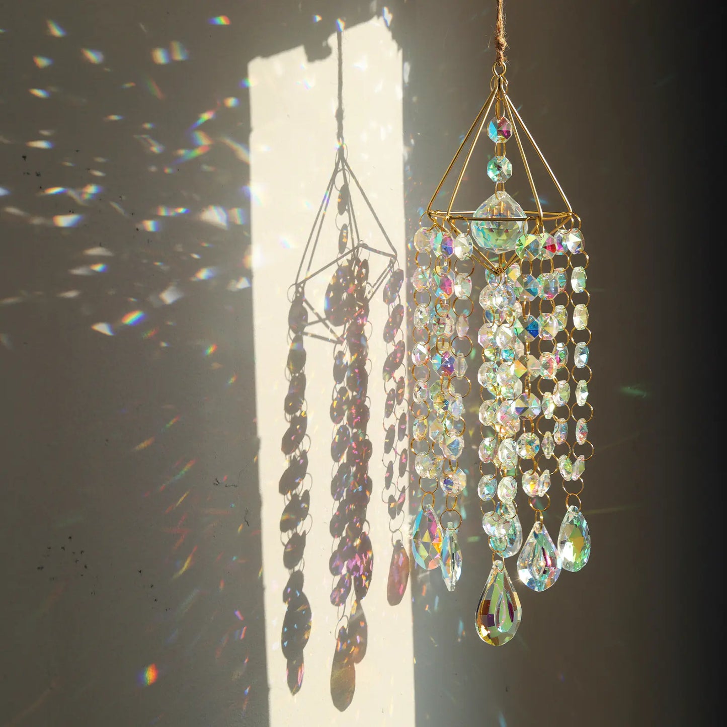 Decorative hanging crystal chandelier with sunlight casting shadows on a plain background