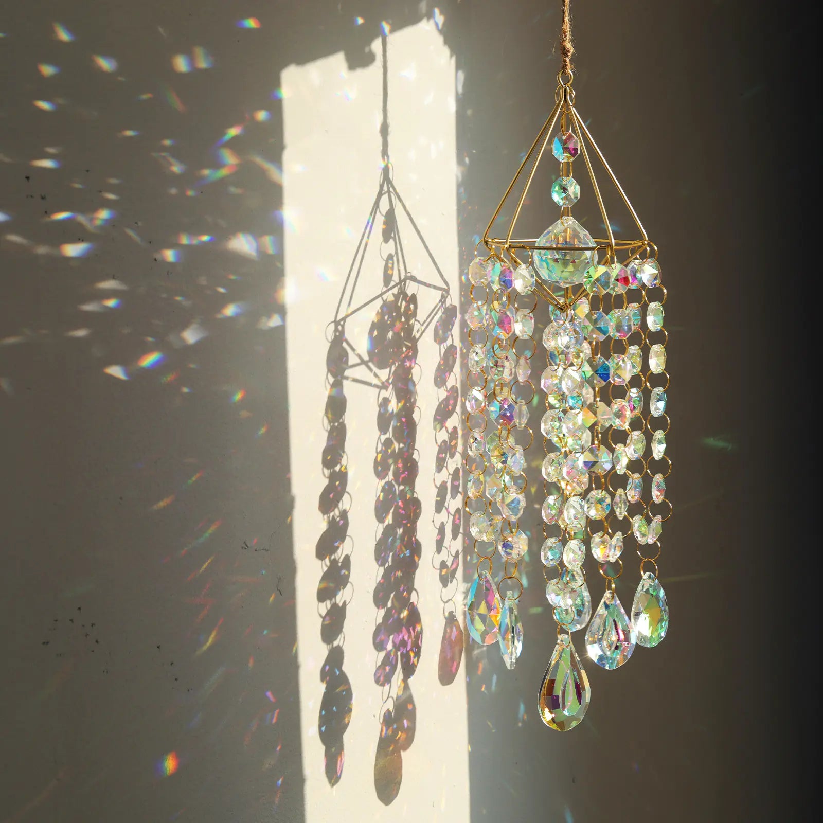 Decorative hanging crystal chandelier with sunlight casting shadows on a plain background