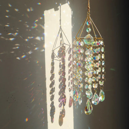 Decorative hanging crystal chandelier with sunlight casting shadows on a plain background